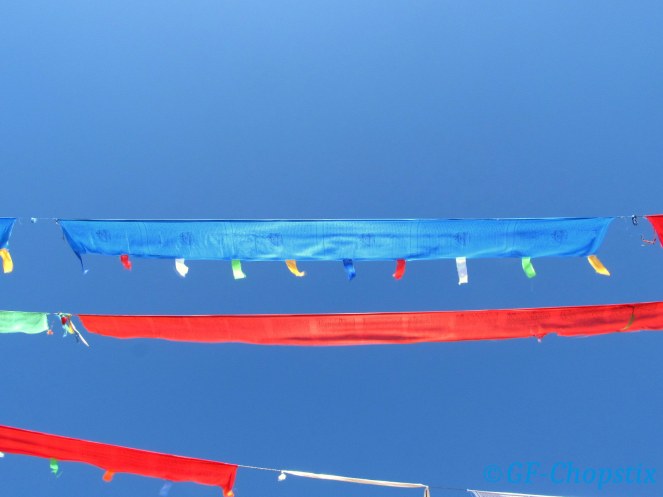 Vibrant prayer flags with a stunning clear sky as a backdrop
